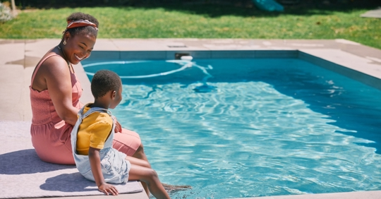 Mon and child dipping in the pool